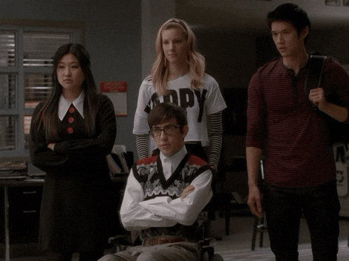 a girl wearing a shirt that says " happy " stands next to a boy in a wheelchair