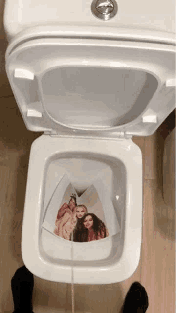 a toilet with a picture of three girls on the seat