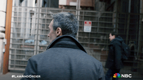 a poster for law and order shows a man walking in front of a building