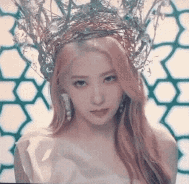 a close up of a woman wearing a crown and a white dress .