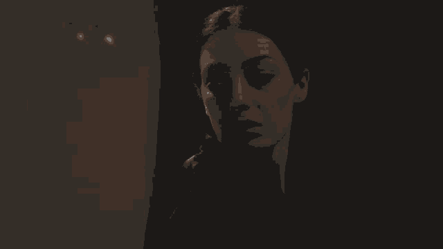 a woman 's face is shown in a dark room with a foreign language caption