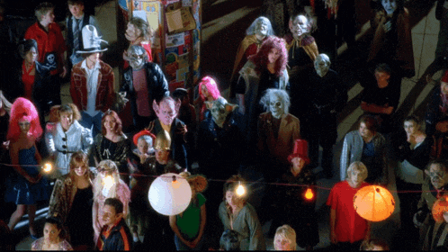 a crowd of people are gathered in a dark room with lanterns