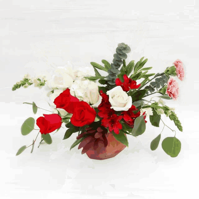 a bouquet of yellow roses red carnations and sunflowers on a white background