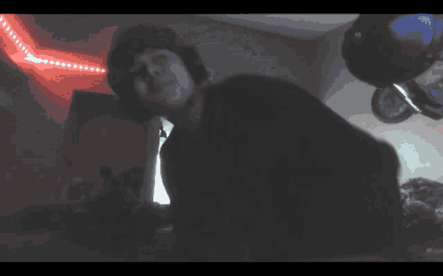 a blurry picture of a person in a dark room with balloons hanging from the ceiling