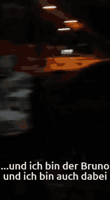 a blurry picture of a dark room with the words " und ich bin der bruno und ich bin auch dabei " on the bottom