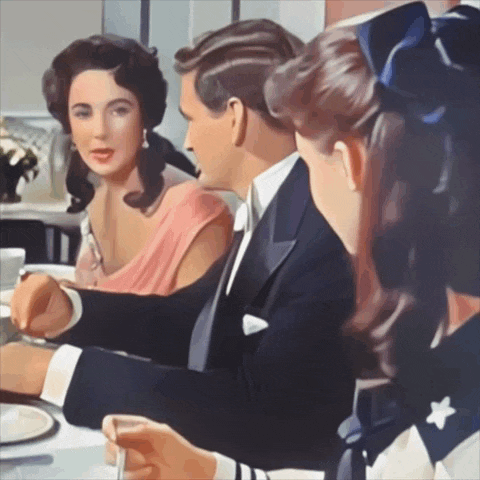 a woman in a pink dress sits next to a man in a suit