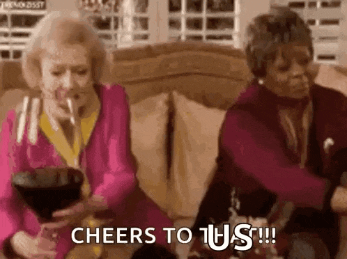 two older women are sitting on a couch drinking wine from glasses .