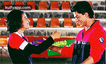 a man and a woman are standing next to each other and shaking hands .