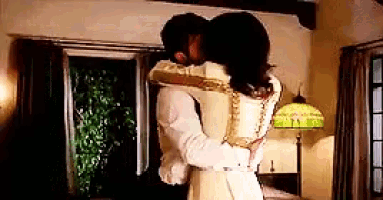 a man and woman are hugging each other in a living room .