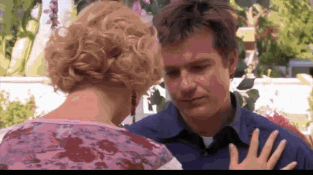 a man and a woman are looking at each other and the man is wearing a blue shirt