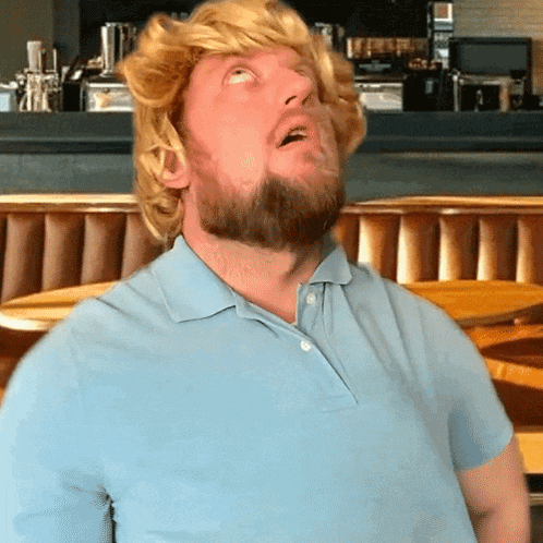 a man with a beard wearing a wig looks up