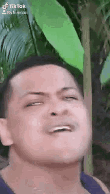 a man is making a funny face with his eyes closed .