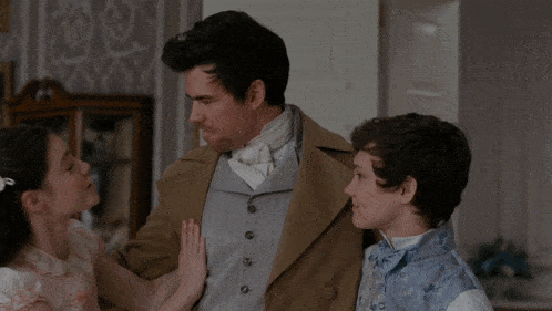 a man and two children are standing together in a room