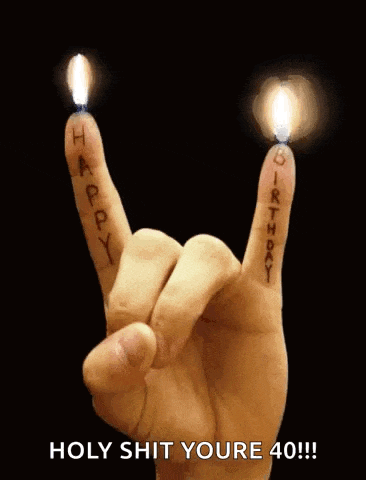 a person 's hand is making a rock and roll sign with candles between their fingers .