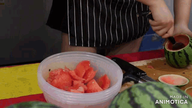a person is cutting a watermelon with a knife and a bowl of watermelon next to it that says made in animatica