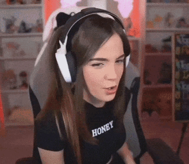 a woman wearing headphones and a shirt that says honey on it