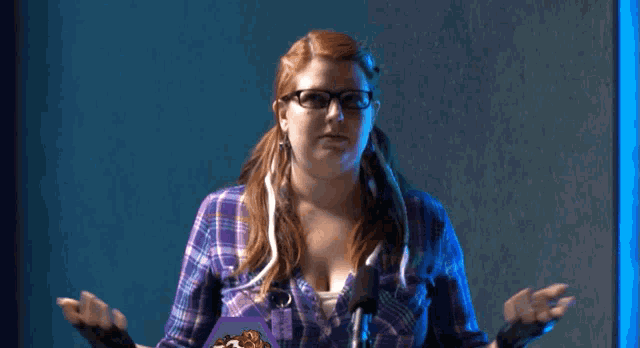 a woman wearing glasses and a plaid shirt says are you fucking kidding me