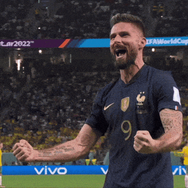 a man with a tattoo on his arm is celebrating a goal in front of a vivo sign