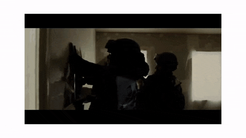 a group of soldiers are standing in a dark room .