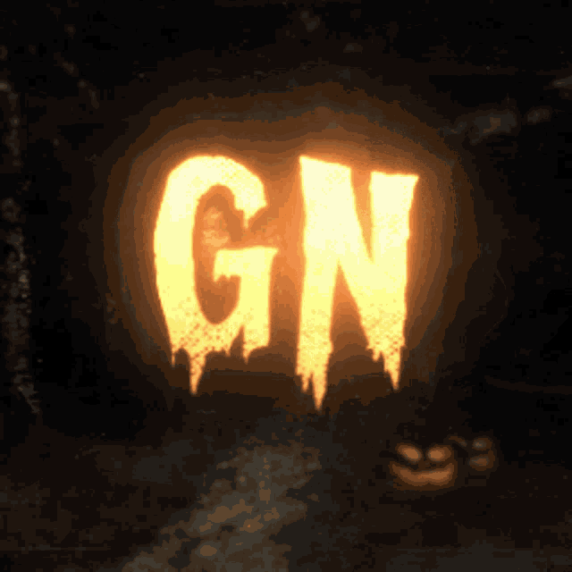 glowing letters gn are carved into a pumpkin