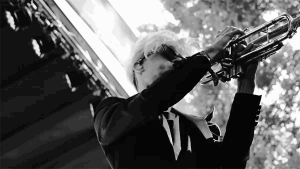 a man is playing a trumpet in a black and white photo