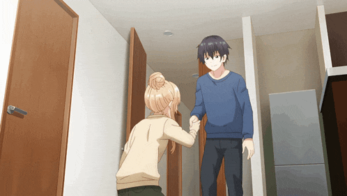 a man and a woman are standing in a hallway holding hands