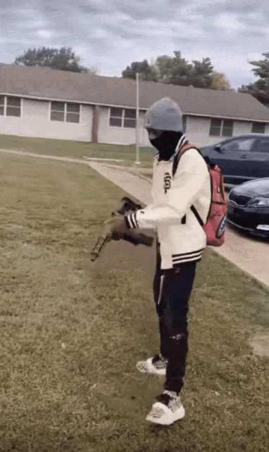 a man holding a gun with a backpack that says ' tcl ' on it