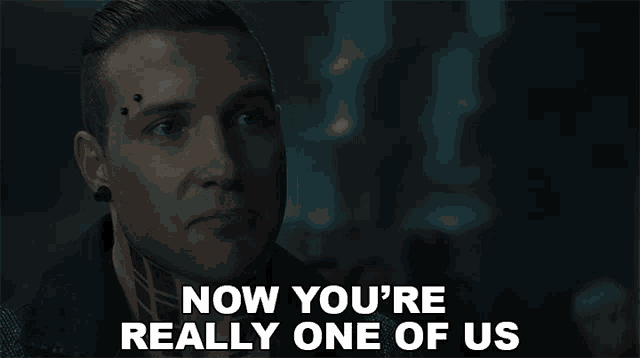 a man with a tattoo on his forehead is saying now you 're really one of us