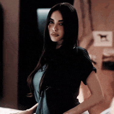 a woman with long dark hair and a nose ring