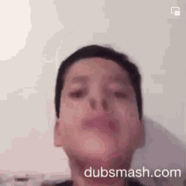 a young boy is making a funny face in front of a camera .