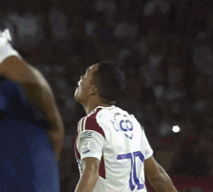 two soccer players hugging each other with one wearing a jersey that says co
