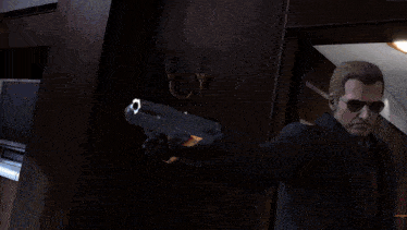 a man in a suit and tie holding two guns