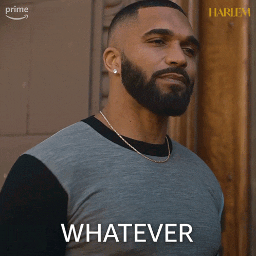 a man with a beard says whatever in front of a harlem poster