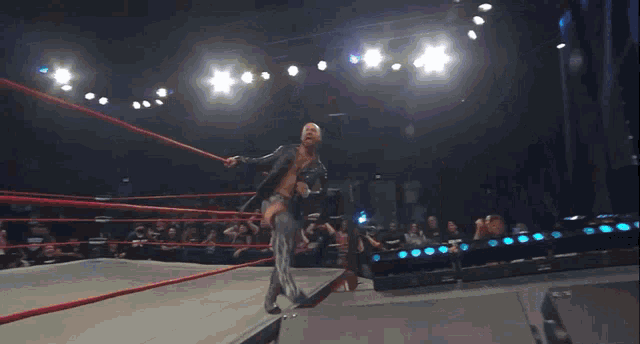 a wrestling match is being held in a ring with a crowd in the background