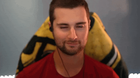 a man with a beard is sitting in a gaming chair with his eyes closed and smiling .