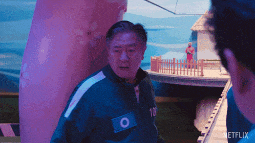 a man in a blue jacket with the number 100 on his chest