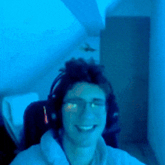 a man wearing headphones and glasses is smiling