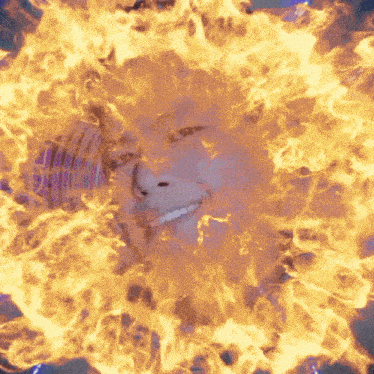 a person 's face is surrounded by flames and smoke