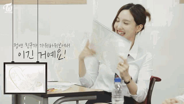 a group of girls sit at desks in a classroom with twice written on the top left