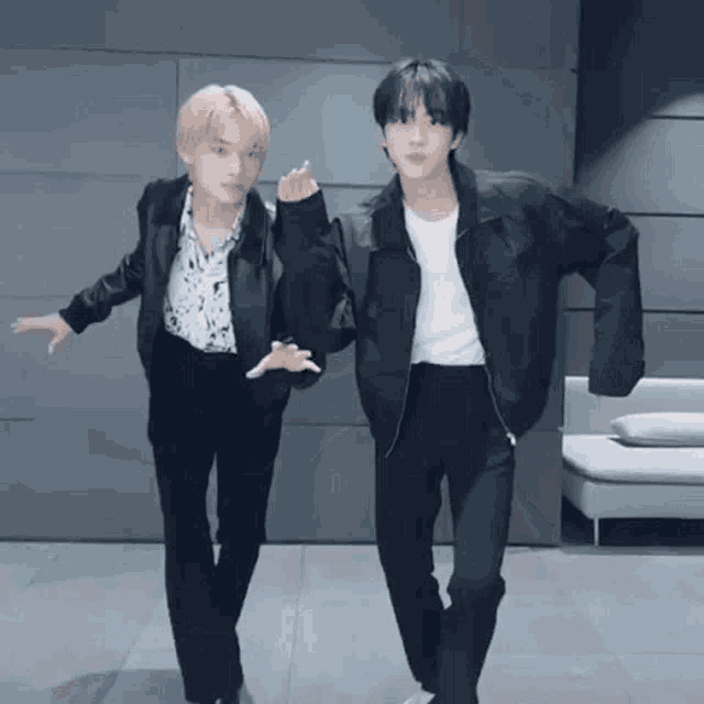a couple of young men are standing next to each other in a room .