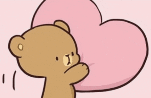 a brown and white teddy bear are laying on a pink pillow .