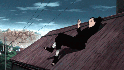 a man is laying on the roof of a building with a statue in the background
