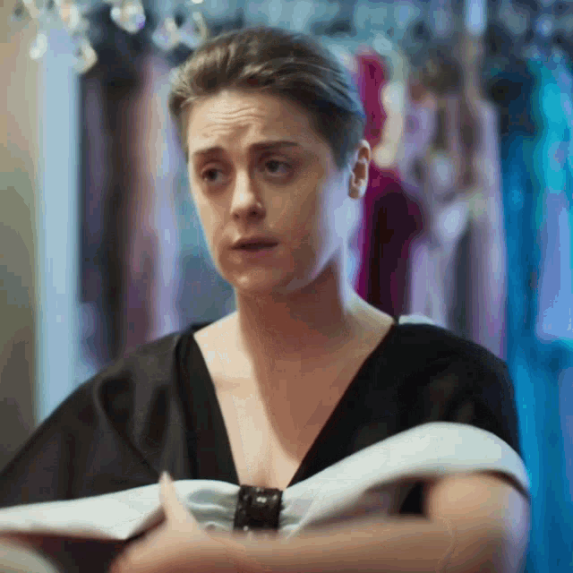 a woman is wearing a black top with a white bow on it