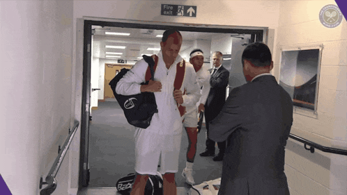 a man carrying a bag with the word racquet on it