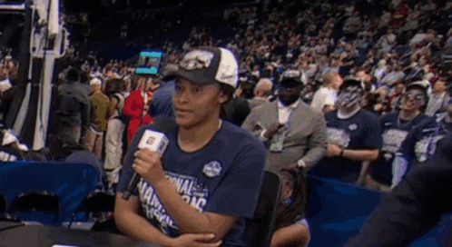 a woman wearing a national champions shirt is holding a microphone