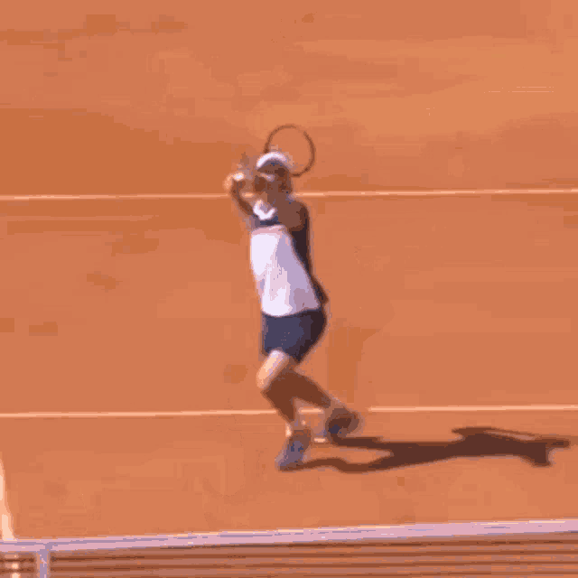 a man is holding a tennis racquet and playing tennis on a court .