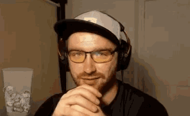 a man wearing glasses and headphones is making a face .