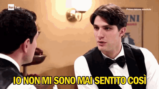 a man in a tuxedo is talking to another man with the words " io non mi sono mai sentito così " below him