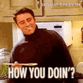 a man in a black turtleneck is holding a plate of food and smiling .