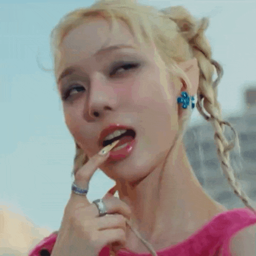 a close up of a woman eating a candy with her tongue out .